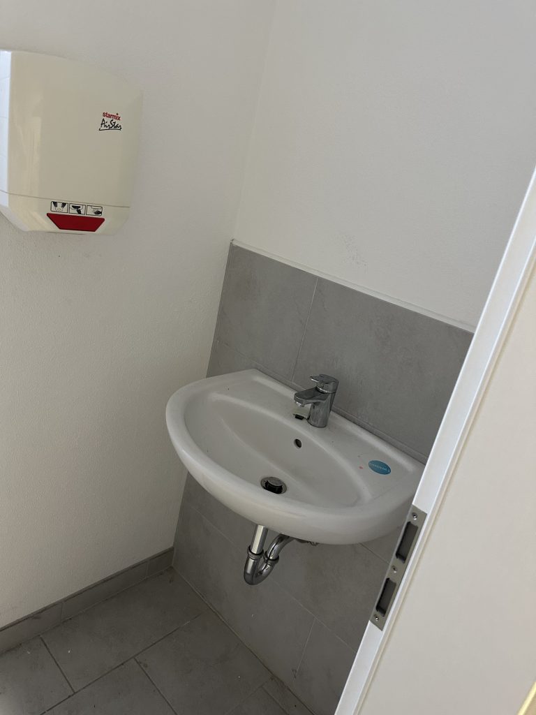 Sauberer Waschbeckenbereich in einer kleinen Toilette